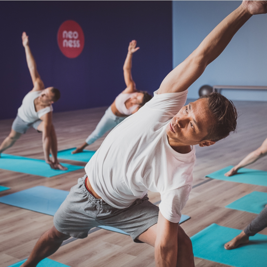 Homme s'étire durant un cours de Neo Yoga à Neoness