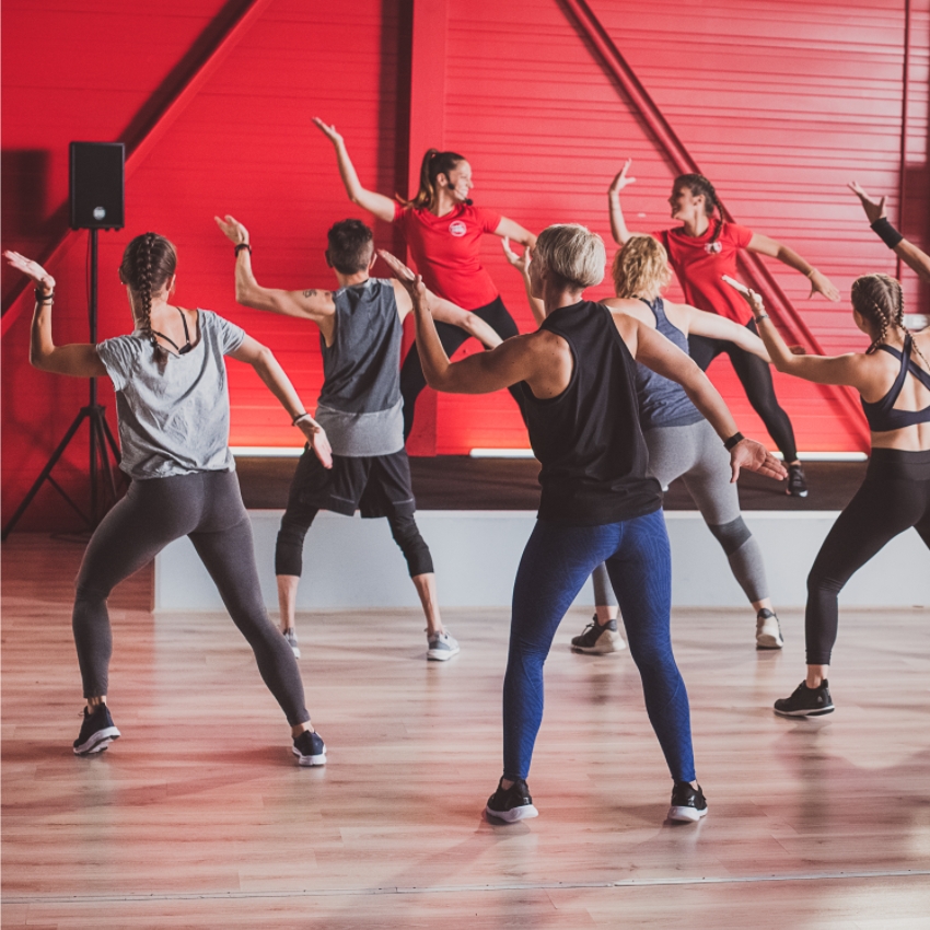 Professeures et élèves dansent la zumba durant un cours de sport